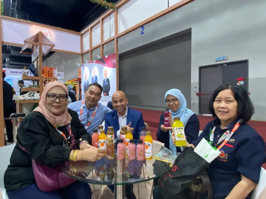 MIHAS 2026 exhibitors displaying bottled beverage products with printed labels and branded packaging